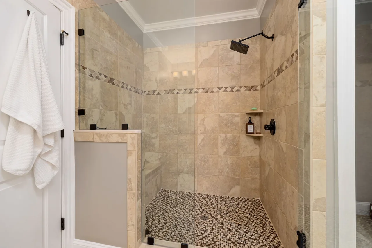 Shower with a mosaic tile band and mosaic floor