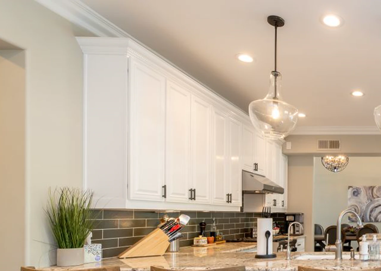 Dark subway tile backsplash with light grout, white cabinets, and a counter